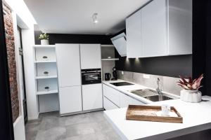布鲁塞尔Smartflats - Bourse Brussels的白色的厨房,配有黑色的墙壁和白色的橱柜