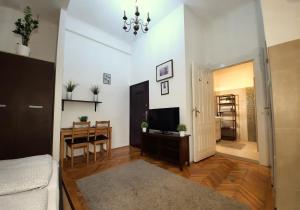 布达佩斯中央金子公寓的客厅配有桌子和电视