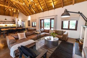 帕拉博鲁瓦Kingly Bush Villa的带沙发的客厅和用餐室