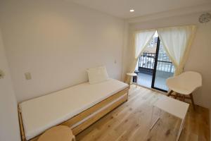 东京Enzo Tokyo的小房间设有床和窗户