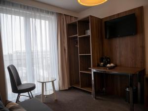 海牙Hotel Hague Center的酒店客房配有书桌和电视。