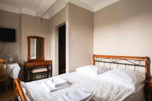 华沙国西尼亚克高级酒店的一间卧室配有一张带白色床单和镜子的床