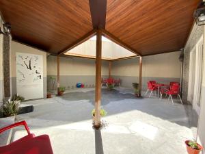 梅利德奥波谷佩雷罗旅舍的一个带红色椅子和木制天花板的大型凉亭
