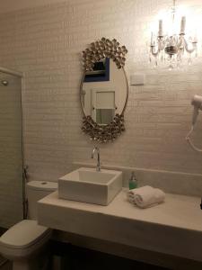 欧鲁普雷图Suite Família Inconfidentes的一间带水槽、镜子和卫生间的浴室