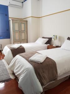 欧鲁普雷图Suite Família Inconfidentes的一间卧室配有两张带白色床单和棕色毯子的床