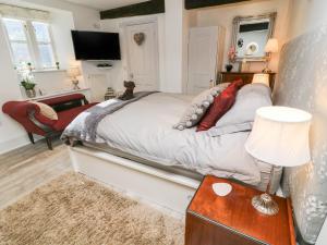 格拉辛顿Blacksmith Cottage的一间卧室配有一张床和一张带台灯的桌子