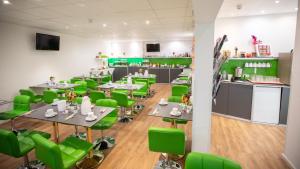 卡尔斯鲁厄阿斯托里亚酒店的用餐室配有绿色的椅子和桌子