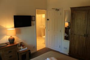Froggatt契克斯旅馆的一间卧室设有卫生间和一台电视。