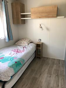 波讷地区圣朱利安Mobile Home - Les Dunes de Contis的一间铺有木地板的小卧室,配有一张床