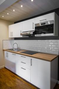 拉穆拉Le Refuge的厨房配有白色橱柜、水槽和微波炉