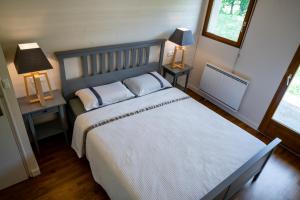 拉穆拉Le Refuge的一间卧室配有一张大床、两张桌子和两盏灯。