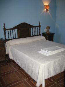 El AlmiceránCortijo El Rey的一间卧室配有一张带白色床单和一盏灯的床。