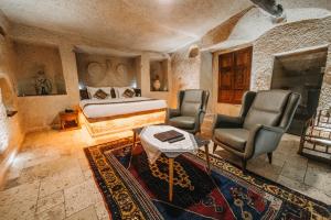 格雷梅埃伦贝洞穴酒店的一间卧室配有一张床、两把椅子和一张桌子
