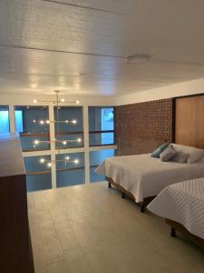 危地马拉君悦太阳酒店的一间卧室设有一张床和砖墙