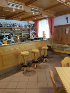 塞纳莱斯Gasthof Neuratheis的餐厅前方设有带凳子的酒吧