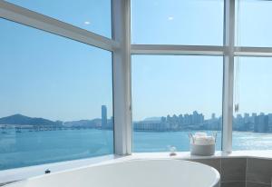 釜山H Avenue Gwanganri Beach的带浴缸的浴室和大窗户