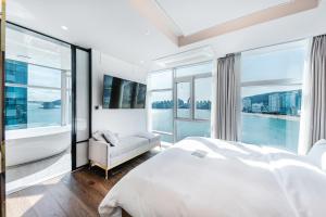 釜山H Avenue Gwanganri Beach的卧室设有一张白色大床和大窗户