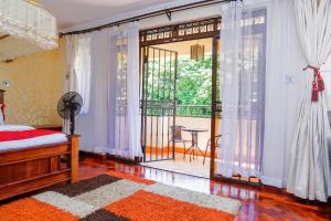 内罗毕吉吉里兰花屋住宿加早餐旅馆的一间卧室设有一张床和一个阳台的大窗户