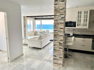 马贝拉Luxury Puerto Banus Penthouse With Parking & WI-FI的中间设有带石柱的白色厨房