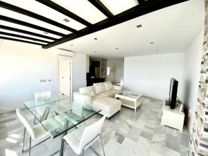 马贝拉Luxury Puerto Banus Penthouse With Parking & WI-FI的客厅配有玻璃桌和白色家具