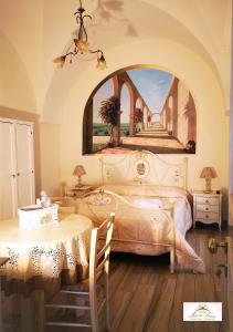 马丁纳弗兰卡Archetto Bianco的一间卧室配有一张带桌子和绘画的床
