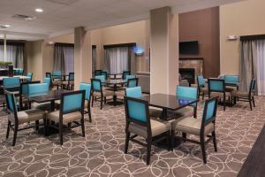 贝克斯菲尔德Holiday Inn Express & Suites Bakersfield Airport, an IHG Hotel的一间带桌椅和壁炉的用餐室