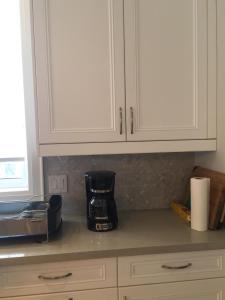 皮克灵Comfortable private space的配有白色橱柜和咖啡壶的厨房台面