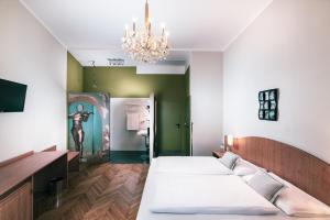 维也纳BoutiqueHOTEL Donauwalzer的带三张床和吊灯的客房