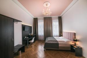 维也纳BoutiqueHOTEL Donauwalzer的一间卧室配有一张大床和一个吊灯。