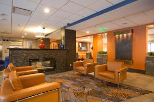 安条克Holiday Inn Express & Suites Nashville Southeast - Antioch, an IHG Hotel的一间设有椅子和壁炉的等候室