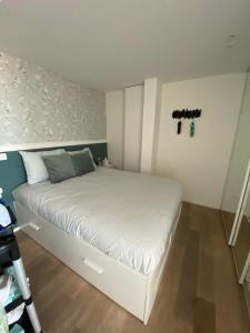 奥斯坦德hill4的一间小卧室,配有一张白色的墙壁上的十字架床