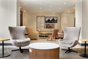 休斯顿休斯敦洲际机场假日酒店的一间设有椅子和桌子的等候室