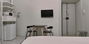 罗马La stanza di Camillo的配有桌椅和墙上电视的房间