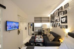 巴黎Résidence Voûte的客厅配有沙发和墙上的电视