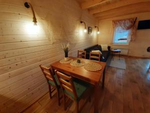 鲁恰内尼达Chaty Mazur w Wierzbie的木制用餐室配有桌椅