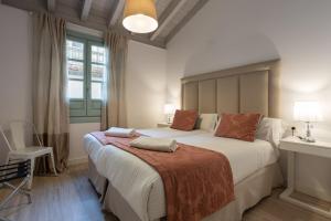 格拉纳达帕拉西奥卡布雷拉利洛公寓的一间卧室设有一张大床和一个窗户。