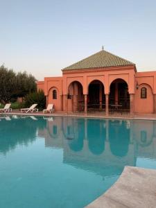 马拉喀什Villa avec piscine a Marrakech的一座大水池,后面有一座建筑