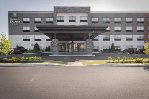 兰道夫Holiday Inn Express & Suites - Boston South - Randolph, an IHG Hotel的前面有停车位的大楼