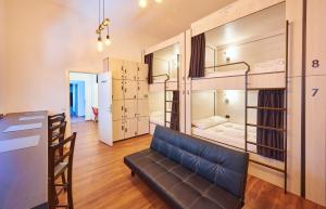 布拉索夫SECRET boutique Hostel的一间配有沙发的房间和一间配有双层床的房间