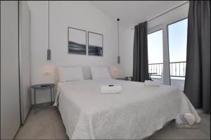 德朗西斯Apartmani Miranda的白色卧室设有一张大床和一个阳台
