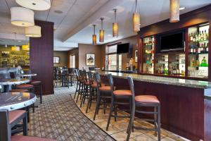绿湾Holiday Inn & Suites Green Bay Stadium, an IHG Hotel的餐厅的酒吧,有一堆凳子