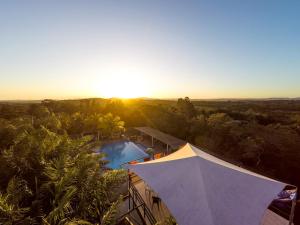 圣伊格纳西奥Rumors Resort Hotel的享有带游泳池的度假村的顶部景致和日落美景