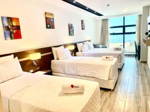 恩卡纳西翁Hotel Sun的酒店客房设有两张床和大窗户。
