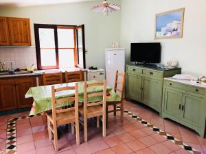 卡洛福泰Villetta al Mare circondata dal Verde (Carloforte - Spalmatore)的厨房配有桌椅和冰箱。