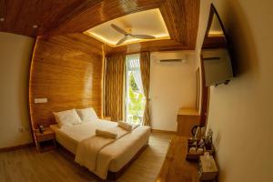 丹格迪PERLA Dhangethi的一间卧室设有一张大床和一个窗户。