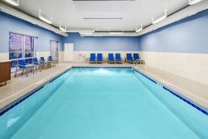 奈尔斯奈尔斯旅行者酒店 的大楼内带蓝色椅子的游泳池