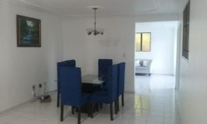 圣地亚哥洛斯卡巴Amplio y acogedor apartamento的一间配备有蓝色椅子和桌子的用餐室