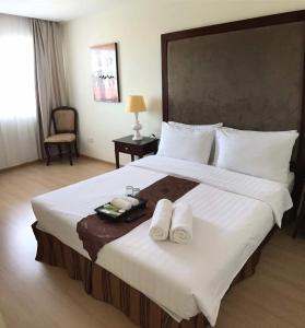 斯里巴加湾市首都居所套房酒店的一间卧室配有一张大床和两条毛巾