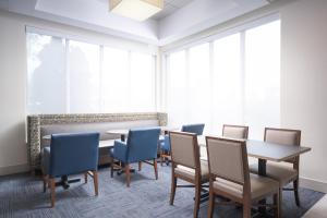 查塔努加查塔努加 市中心智选假日套房酒店的一间会议室,配有桌椅和大窗户