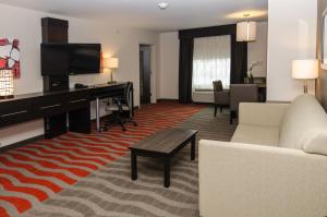 杰汉奈Holiday Inn Express & Suites Columbus - Easton Area, an IHG Hotel的一间客厅,客厅配有沙发和一张书桌,位于酒店的房间